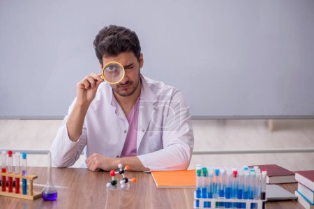 Photo for Young chemistry teacher sitting in the classroom - Royalty Free Image