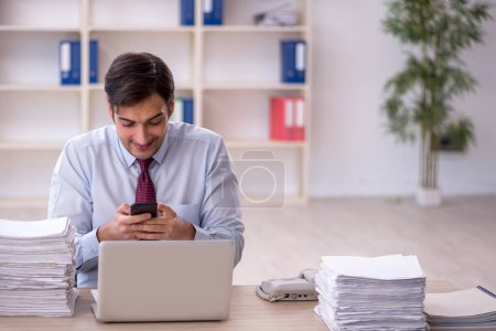 Photo for Young businessman employee and too much work in the office - Royalty Free Image