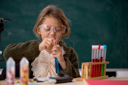 Photo for Young small girl chemist in the classroom - Royalty Free Image