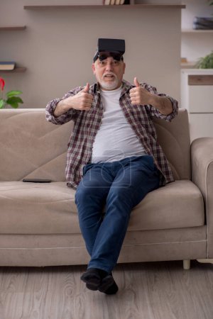 Téléchargez les photos : Old man enjoying virtual glasses at home - en image libre de droit