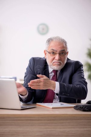 Photo for Old businessman employee and too much work at workplace - Royalty Free Image