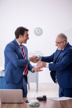 Téléchargez les photos : Two male employees with star award in the office - en image libre de droit