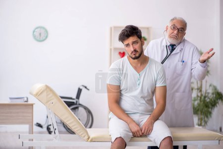 Foto de Paciente joven visitando viejo médico masculino - Imagen libre de derechos