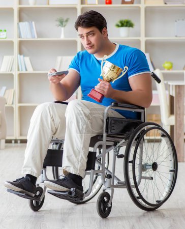 Téléchargez les photos : L'homme handicapé regardant le sport à la télévision - en image libre de droit