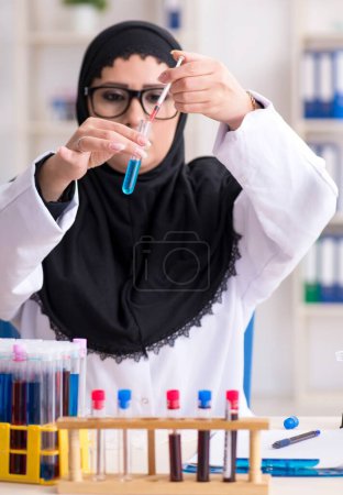 Foto de La química femenina del hiyab que trabaja en el laboratorio - Imagen libre de derechos