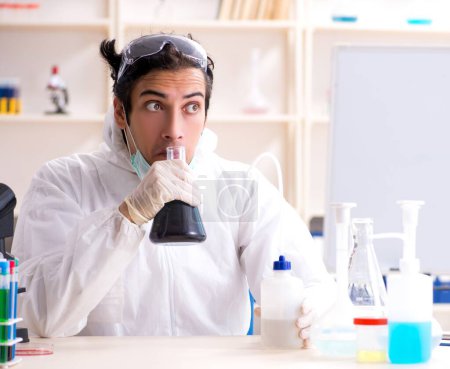 Téléchargez les photos : Le jeune beau chimiste qui travaille au labo - en image libre de droit