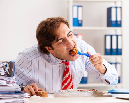 Téléchargez les photos : L'homme qui mange au travail pendant la pause - en image libre de droit