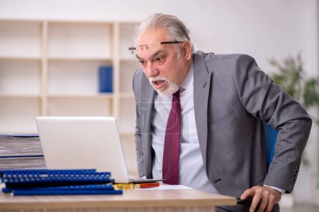 Téléchargez les photos : Ancien patron employé assis sur le lieu de travail - en image libre de droit