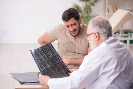 Foto de Paciente joven que visita al viejo radiólogo médico - Imagen libre de derechos
