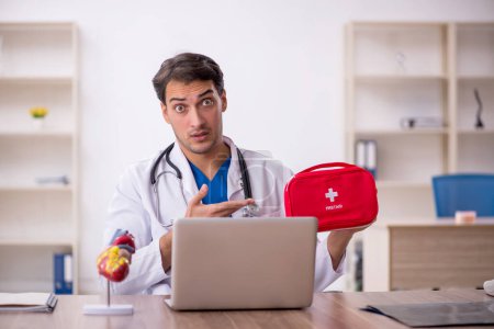 Photo for Young male doctor holding first aid bag - Royalty Free Image
