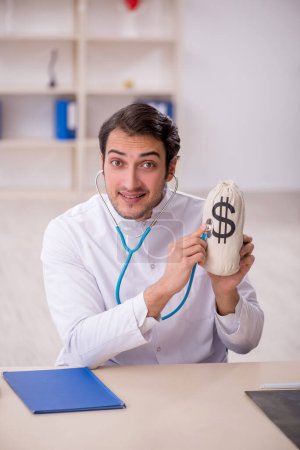 Photo for Young doctor in remuneration concept - Royalty Free Image