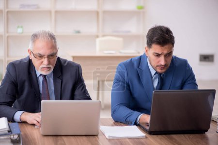 Téléchargez les photos : Deux employés assis sur le lieu de travail - en image libre de droit