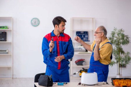Photo for Two repairmen working at workshop - Royalty Free Image