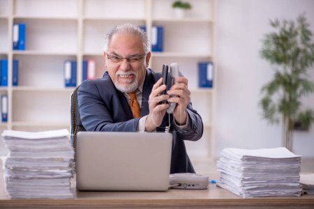Photo for Old businessman employee unhappy with excessive work in the office - Royalty Free Image