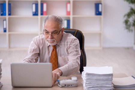 Téléchargez les photos : Vieil homme d'affaires employé mécontent du travail excessif dans le bureau - en image libre de droit