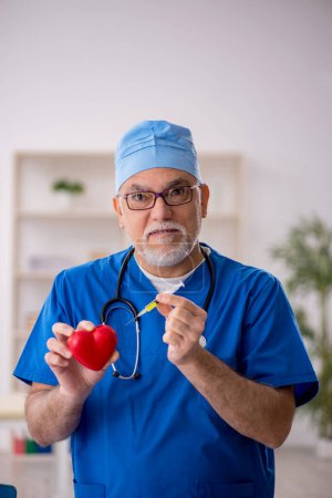 Photo for Old doctor cardiologist working in the clinic - Royalty Free Image