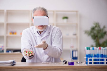 Téléchargez les photos : Old chemist wearing virtual glasses at the lab - en image libre de droit