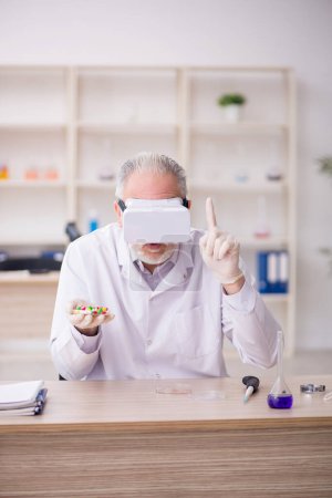 Foto de Old chemist wearing virtual glasses at the lab - Imagen libre de derechos