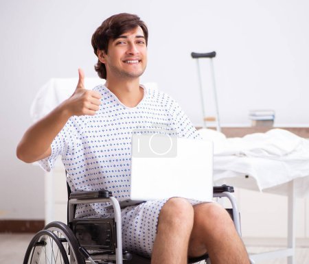 Foto de El joven guapo en silla de ruedas en el hospital - Imagen libre de derechos