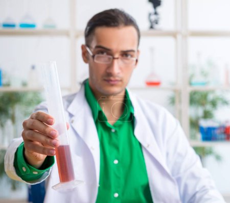 Téléchargez les photos : Le jeune professeur de chimiste masculin dans le laboratoire - en image libre de droit