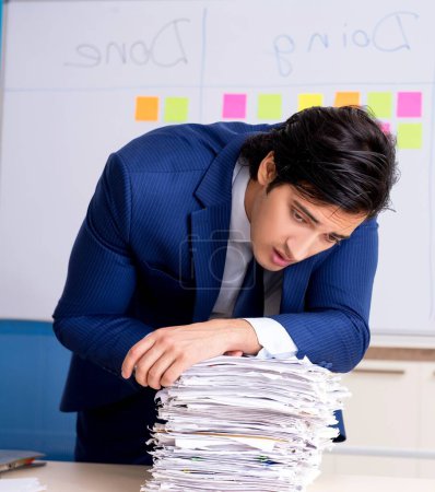 Foto de El joven empleado guapo delante de la pizarra con lista de tareas pendientes - Imagen libre de derechos