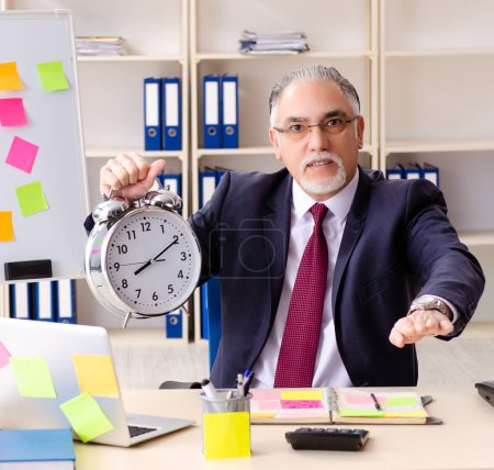 Téléchargez les photos : The aged man employee in conflicting priorities concept - en image libre de droit
