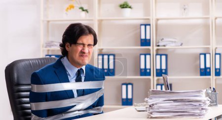 Foto de El joven atado empleado masculino en la oficina - Imagen libre de derechos