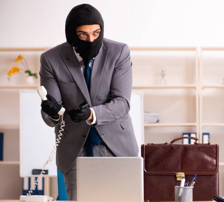 Foto de El gángster masculino robando información de la oficina - Imagen libre de derechos