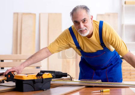 Foto de El viejo carpintero trabajando en el taller - Imagen libre de derechos