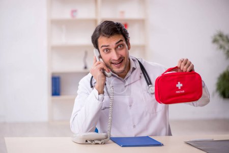 Photo for Young male doctor paramedic holding first aid bag - Royalty Free Image