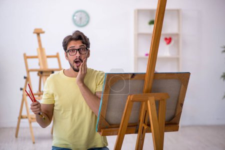 Foto de Joven pintor masculino disfrutando de la pintura en casa - Imagen libre de derechos