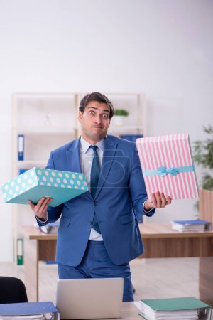 Téléchargez les photos : Jeune homme d'affaires employé fête son anniversaire sur le lieu de travail - en image libre de droit