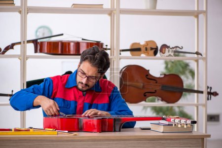Photo for Young man repairing musical instruments indoors - Royalty Free Image