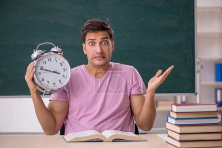 Photo for Young student preparing for exams in time management concept - Royalty Free Image