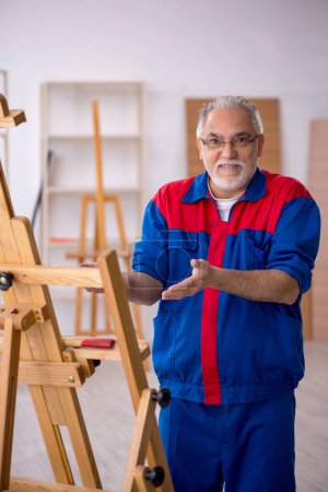 Téléchargez les photos : Vieux charpentier réparation dessin chevalet - en image libre de droit