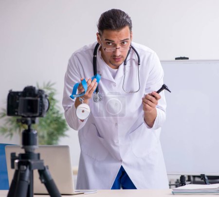 Téléchargez les photos : Le jeune médecin masculin enregistre une vidéo pour son blog - en image libre de droit