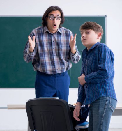 Téléchargez les photos : L'enseignant masculin drôle et garçon dans la salle de classe - en image libre de droit