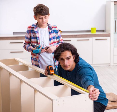 Foto de El joven carpintero enseñando a su hijo - Imagen libre de derechos