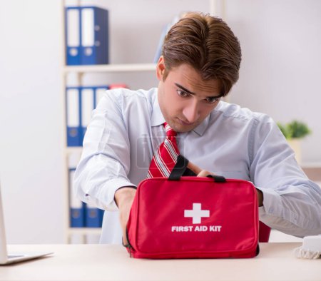 Photo for The man with first aid kit in the office - Royalty Free Image