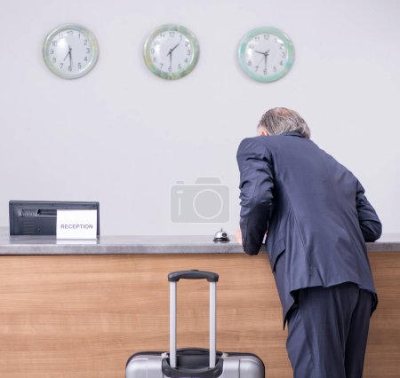 Photo for Old businessman at the hotel reception in business travel concept - Royalty Free Image