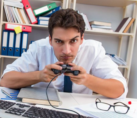 Téléchargez les photos : L'employé jouant à des jeux informatiques dans le bureau - en image libre de droit