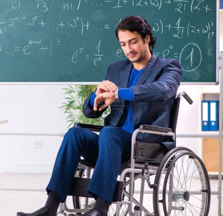 Photo for The young handsome man in wheelchair in front of chalkboard - Royalty Free Image