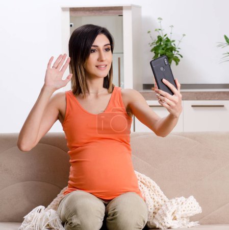 Téléchargez les photos : La jeune femme enceinte à la maison - en image libre de droit