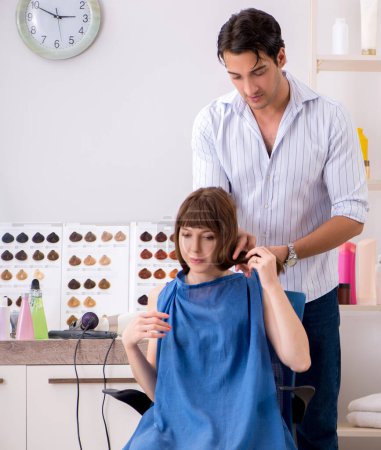 Photo for The young woman visiting young handsome barber - Royalty Free Image