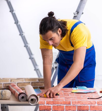 Téléchargez les photos : Le jeune homme entrepreneur en rénovation à la maison - en image libre de droit