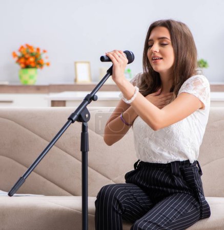 Photo for The female beautiful musician singing at home - Royalty Free Image