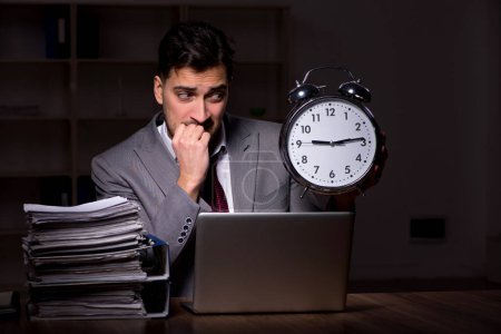 Foto de Young employee working late at workplace - Imagen libre de derechos