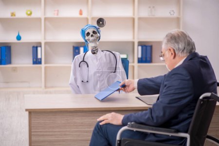 Photo for Old male patient in wheel-chair visiting devil doctor - Royalty Free Image