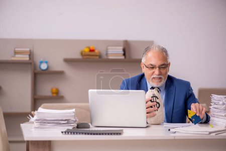 Téléchargez les photos : Ancien patron travaillant à domicile dans le concept de rémunération - en image libre de droit