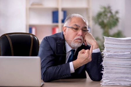 Photo for Old businessman employee and too much work in the office - Royalty Free Image